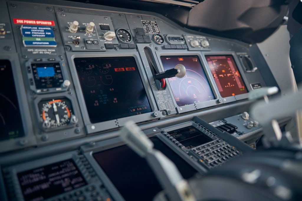 Aircraft flight deck with flight displays, switches and knobs