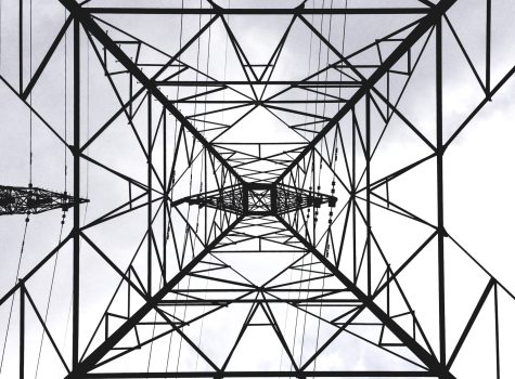 Plane flying over a transmission tower